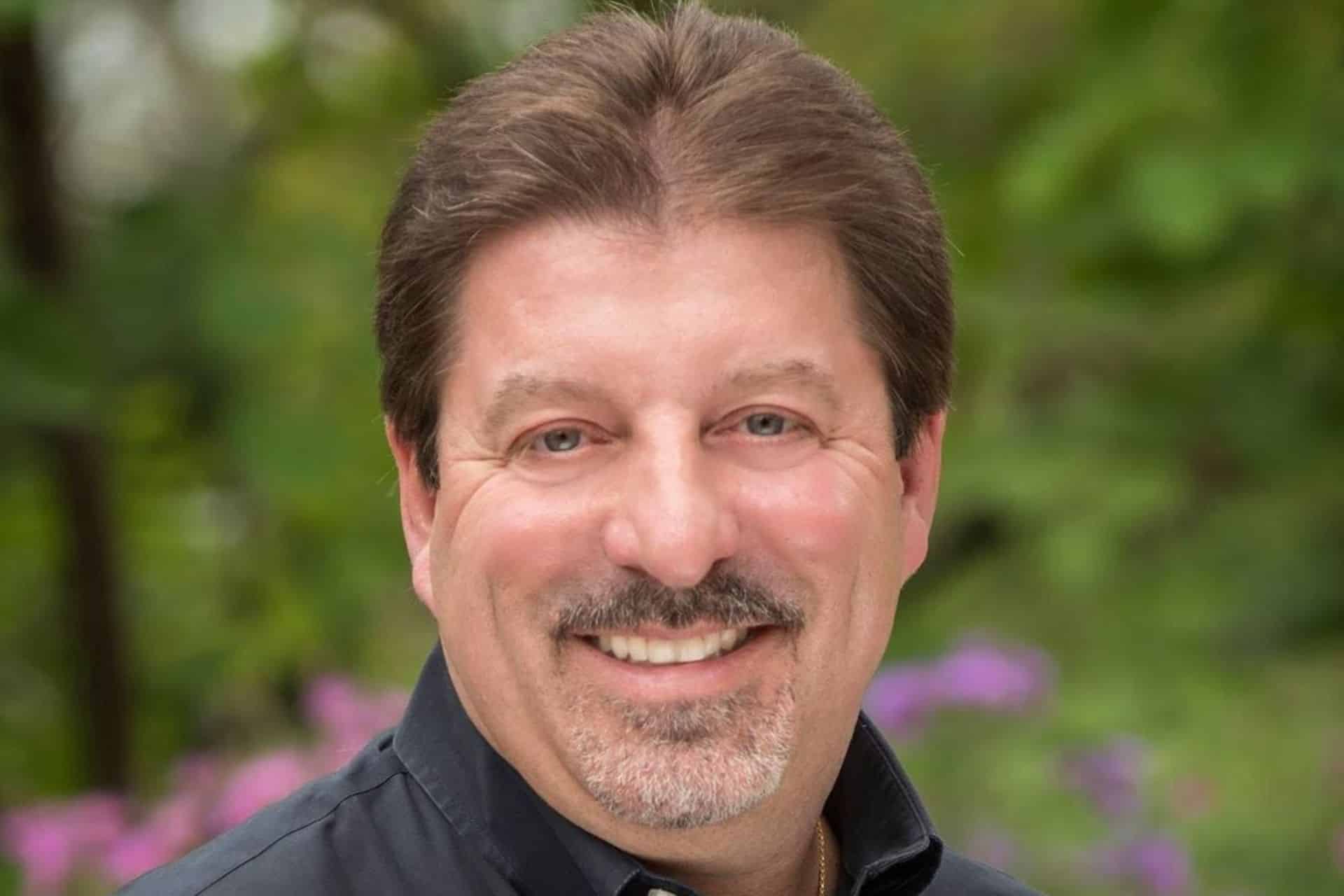 Smiling man with dark hair and mustache | Nudera Orthodontics