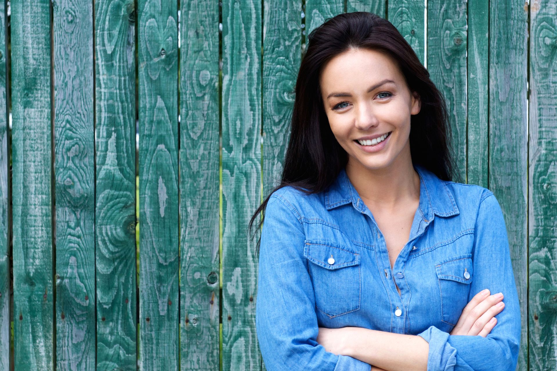 Woman in blue denim shirt smiling | Nudera Orthodontics