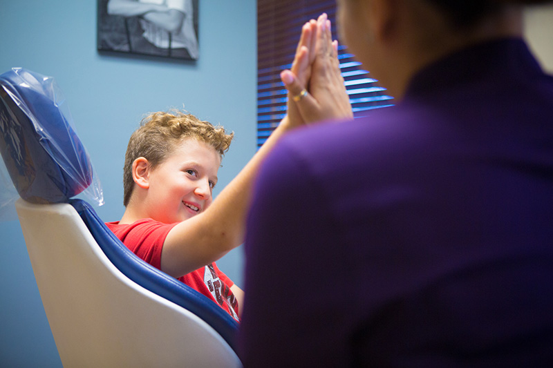 Boy giving high five to staff | Nudera Orthodontics