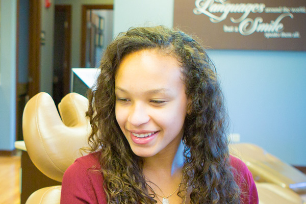 Smiling teenage girl with curly hair | Nudera Orthodontics