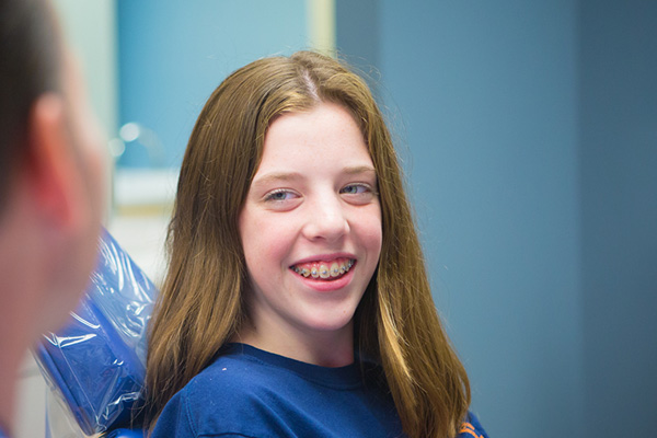 Smiling girl with long brown hair | Nudera Orthodontics