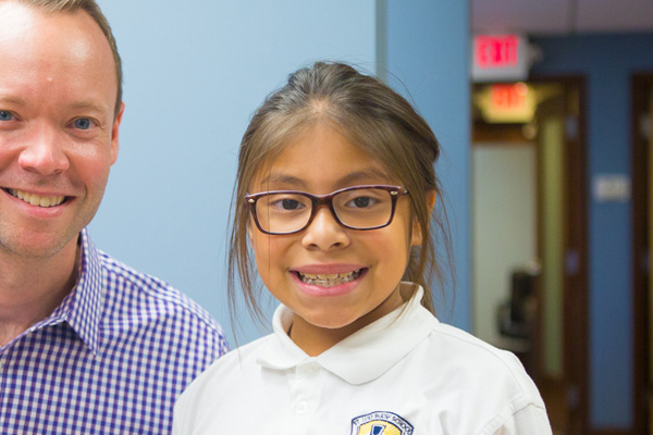 Young girl with glasses smiling | Nudera Orthodontics