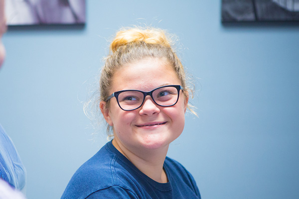 Teenage girl with glasses smiling | Nudera Orthodontics