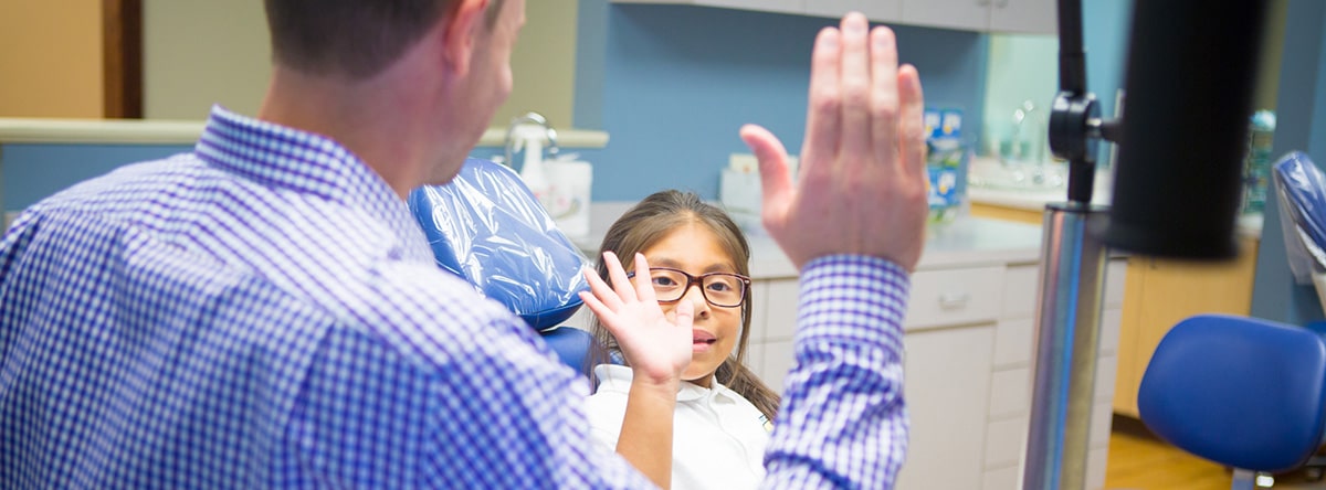 Orthodontist high-fiving young female patient, Nudera Orthodontics