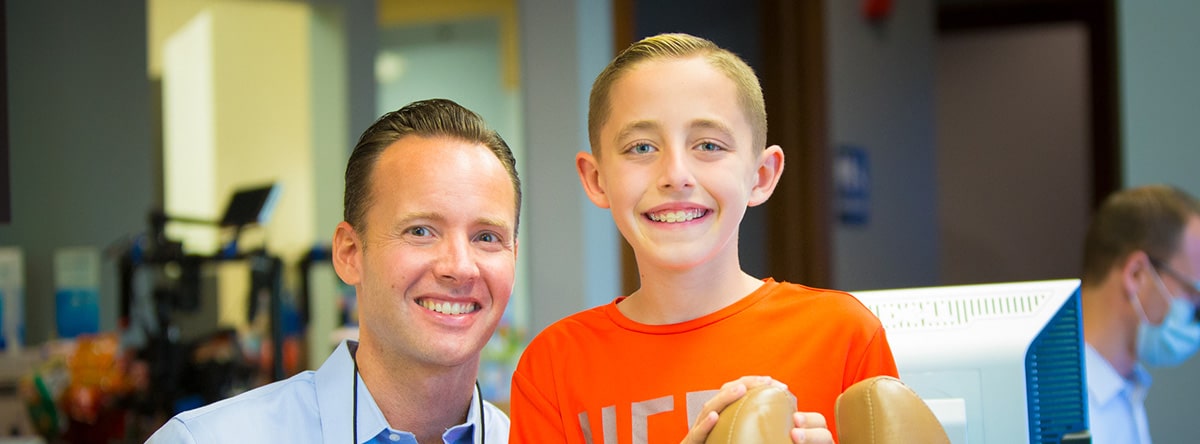 Orthodontist with boy in orange shirt, Nudera Orthodontics