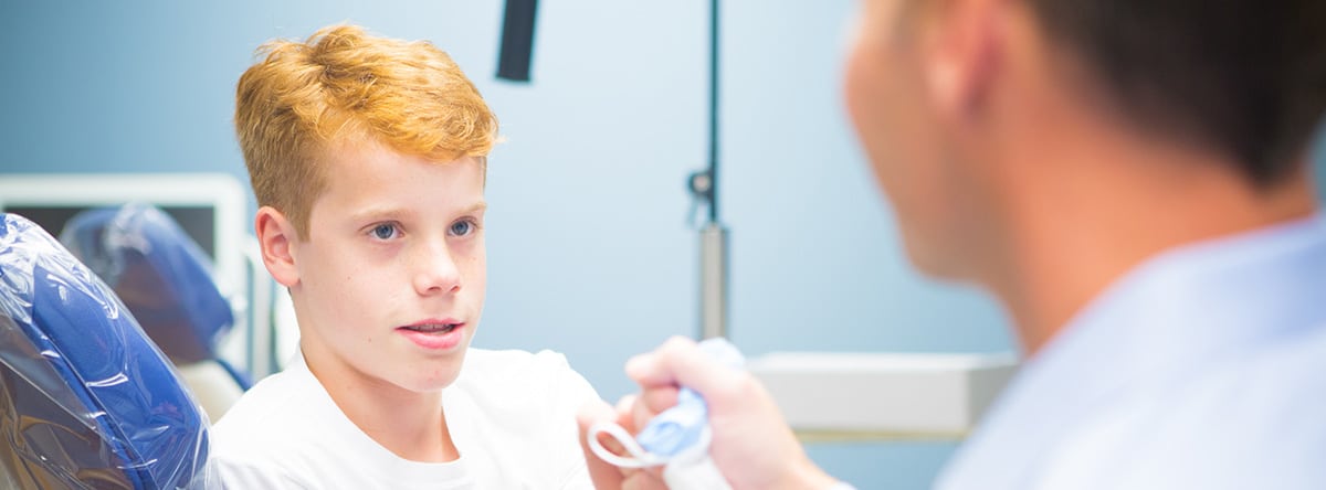 Young boy looking at dental tool | Nudera Orthodontics