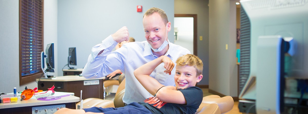 Dr Nudera play-fighting with young boy | Nudera Orthodontics