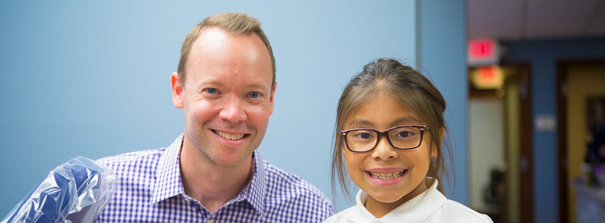 Orthodontist and girl with glasses smiling | Nudera Orthodontics