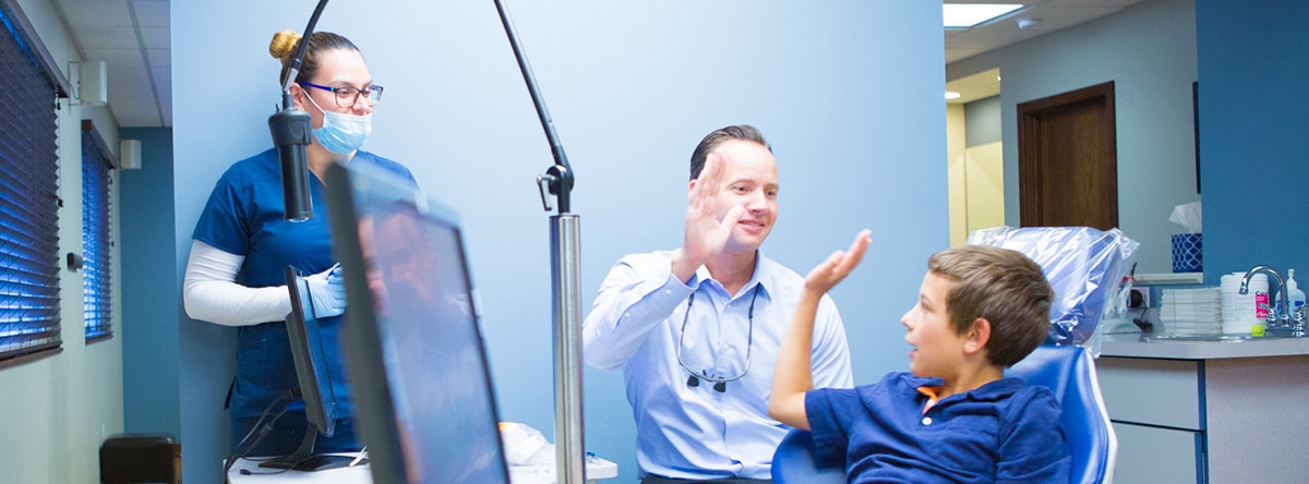 Orthodontist clapping for young patient | Nudera Orthodontics