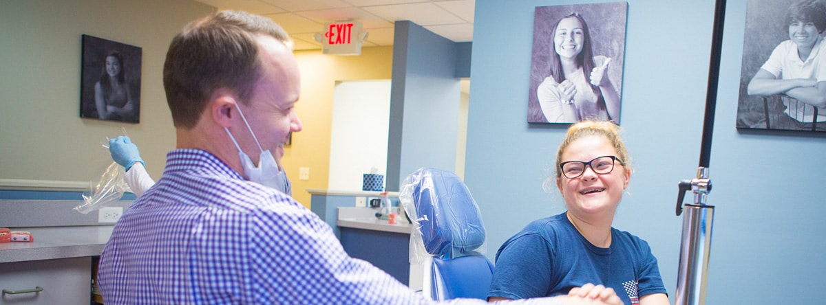 Orthodontist talking to patient in clinic, Nudera Orthodontics